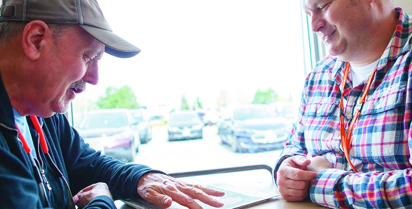 Non-verbal male client working on communication skills with male staff at a local community coffee shop.